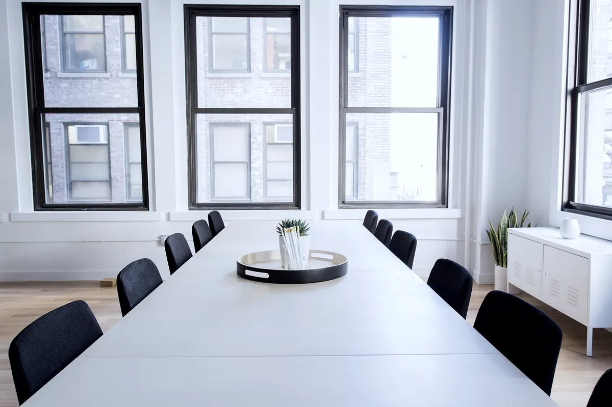Empty minimal meeting room with a long table and chairs