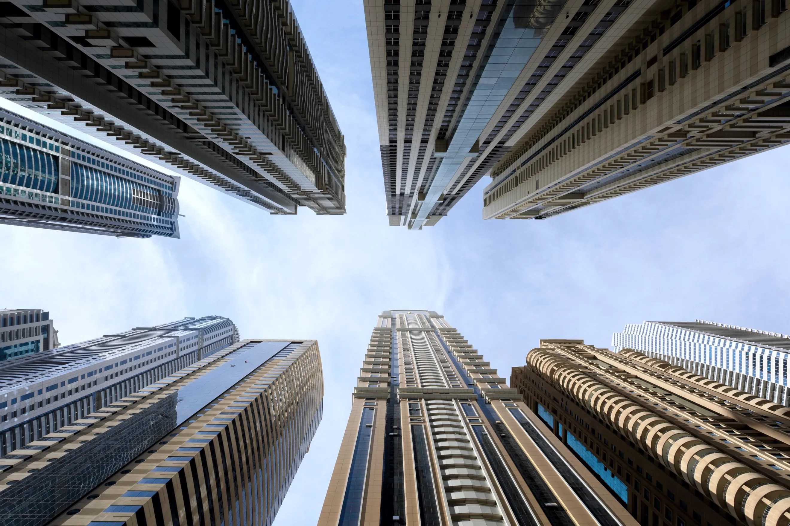 Low angle view of modern high rise buildings against a bright sky