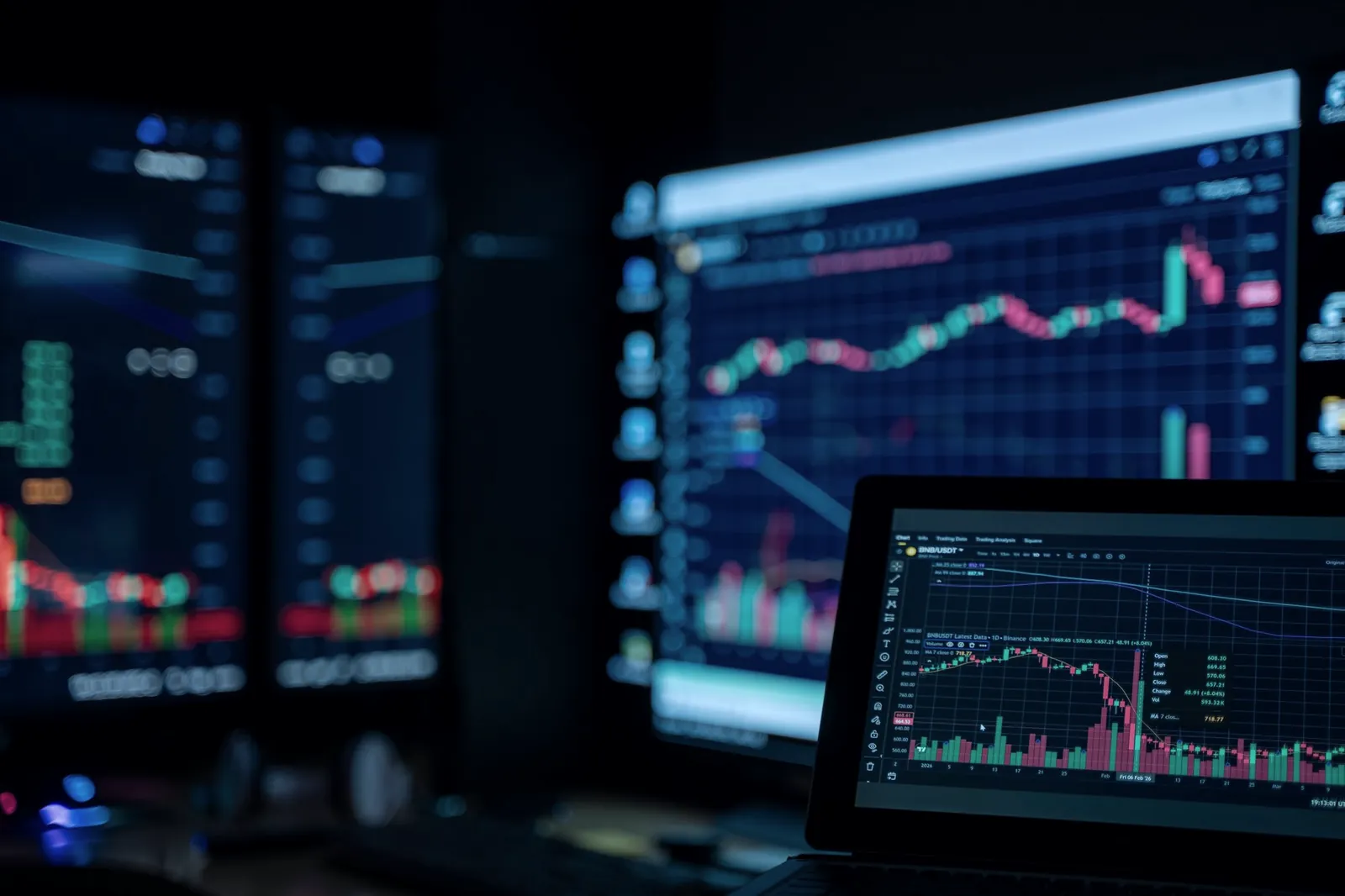Monitors displaying market data in a dimly lit trading environment