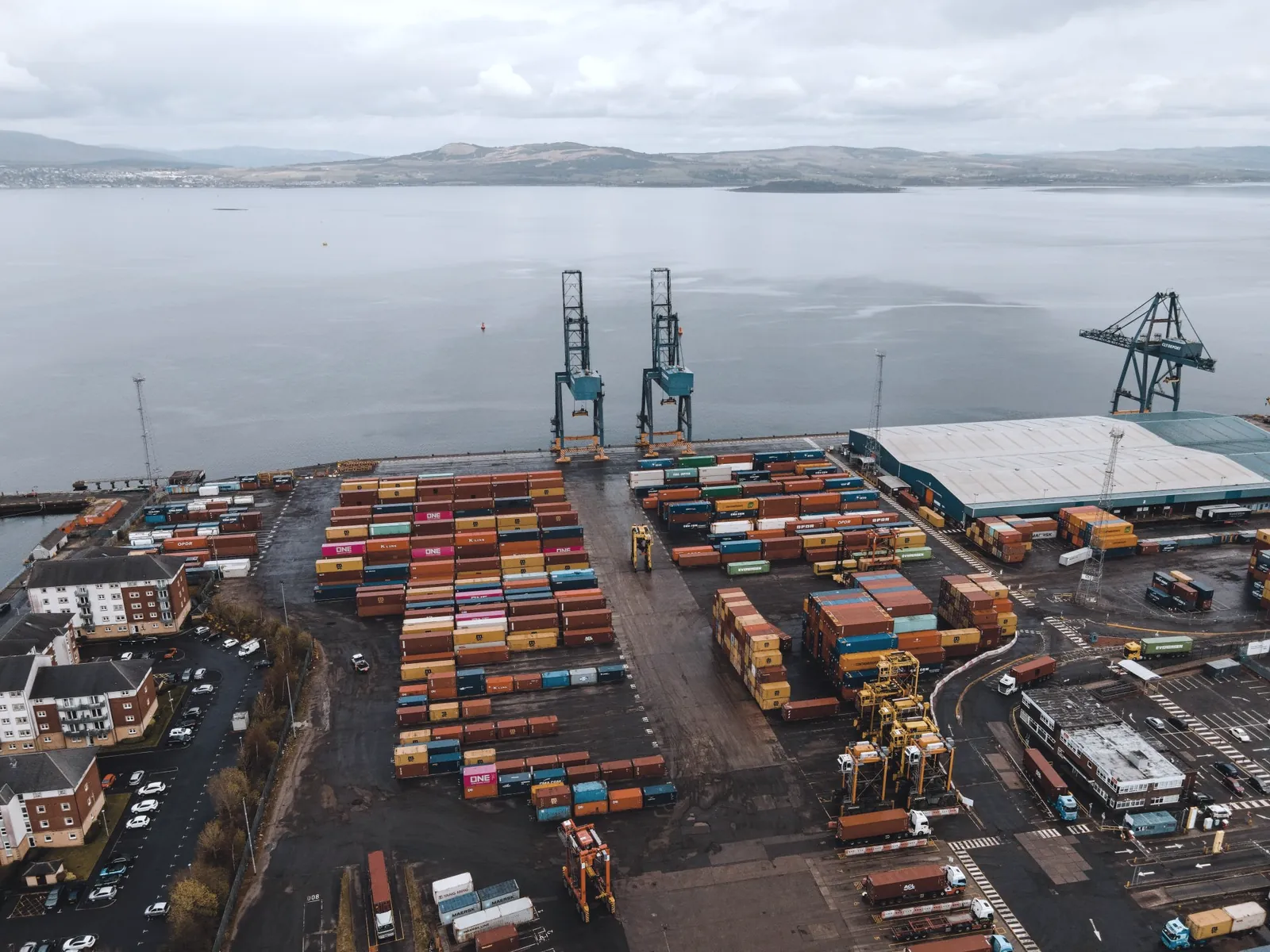 Aerial view of a container port with cranes and stacked containers