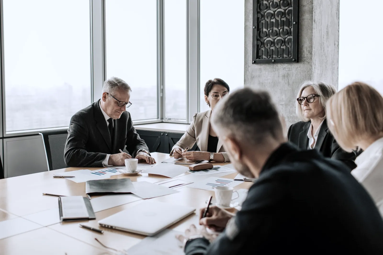 Executives reviewing documents around a boardroom table