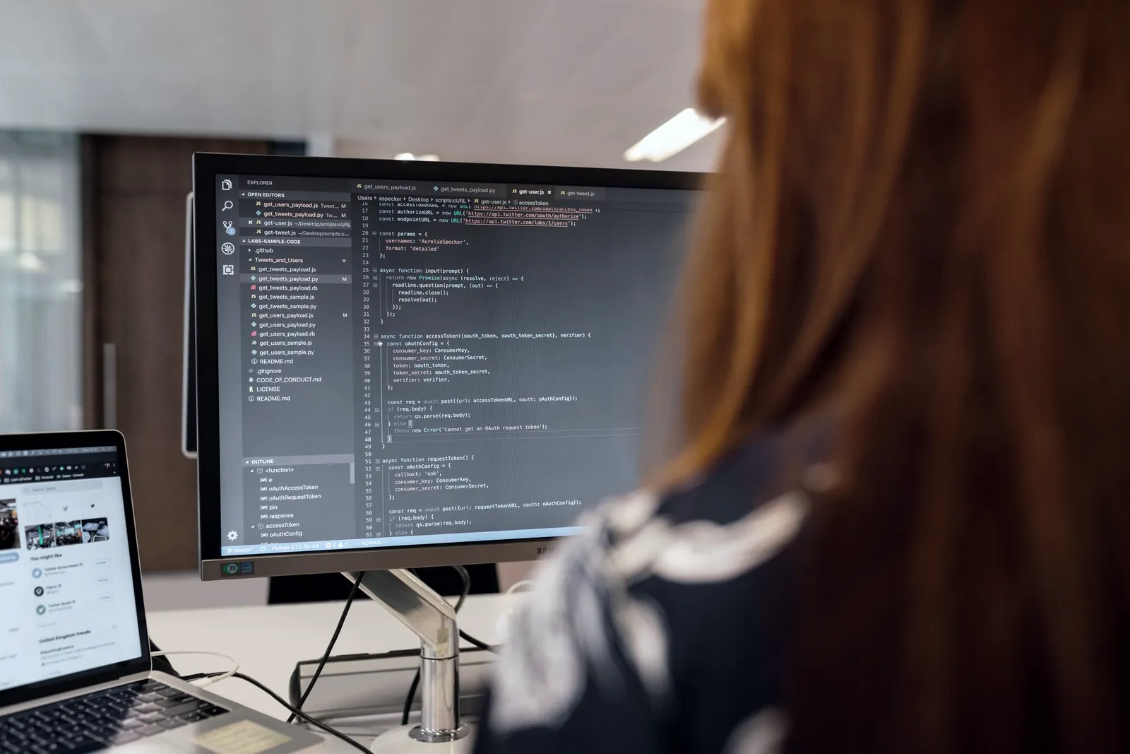 Software engineer writing code on a large monitor