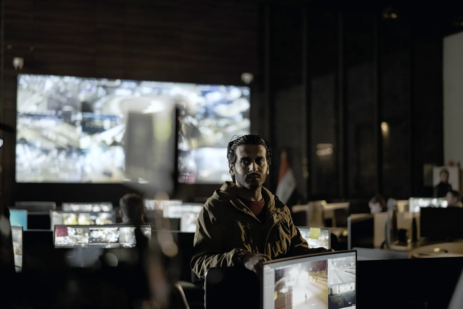 Security operations team monitoring live feeds in a dark control room